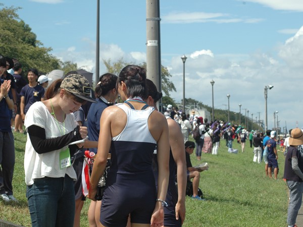 選手に取材する学生スタッフの池澤さん